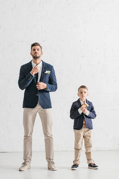 Full length view of father and son in jackets with boutonnieres — Stock Photo