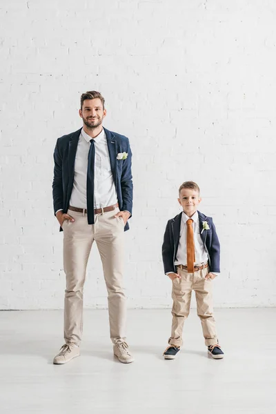 Full length view of father and son in jackets with boutonnieres — Stock Photo