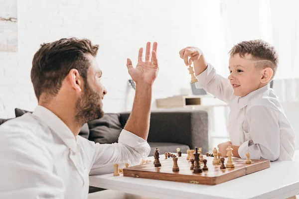 Pai e filho jogando xadrez juntos em casa — Fotografia de Stock