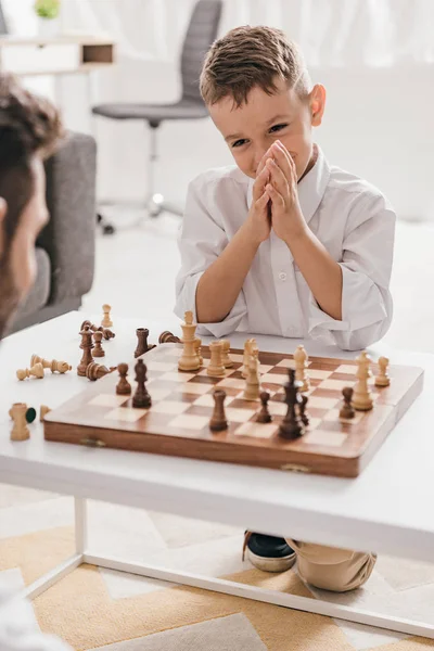 Vista ritagliata di papà e figlio che giocano a scacchi insieme a casa — Foto stock