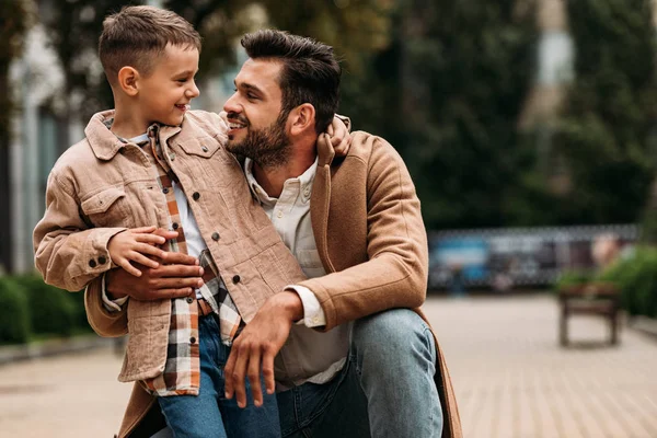 Glücklicher Vater und Sohn, die sich auf der Straße umarmen und anschauen — Stockfoto