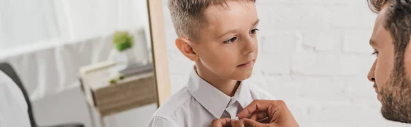 Panoramic shot of father helping son with tie — Stock Photo