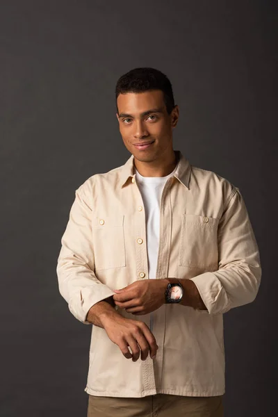 Smiling handsome mixed race man in beige shirt on black background — Stock Photo