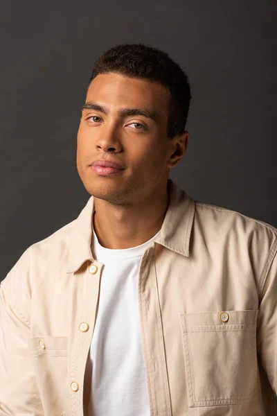 Handsome mixed race man in beige shirt on black background — Stock Photo