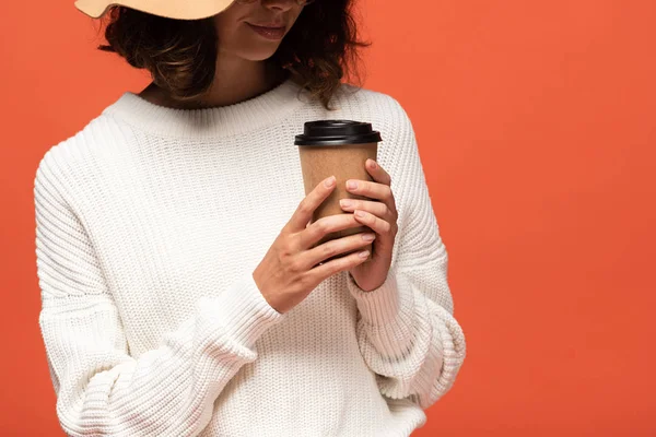 Vista cortada de mulher em chapéu segurando café para ir isolado em laranja — Fotografia de Stock