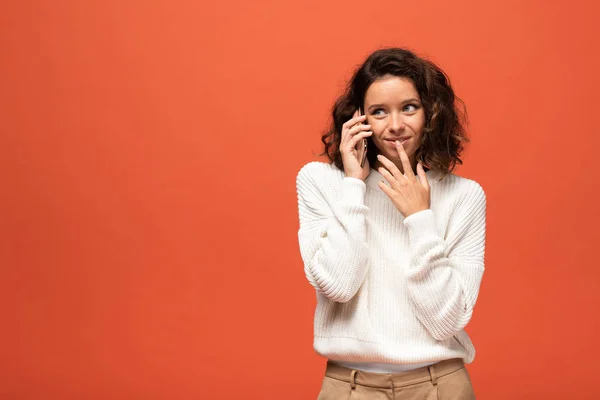 Sorridente donna riccia che parla su smartphone isolato su arancione — Foto stock