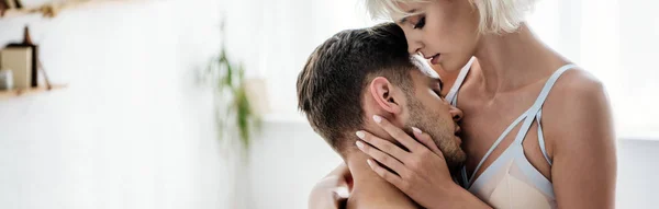 Panoramic shot of  man hugging and kissing blonde woman in bra — Stock Photo