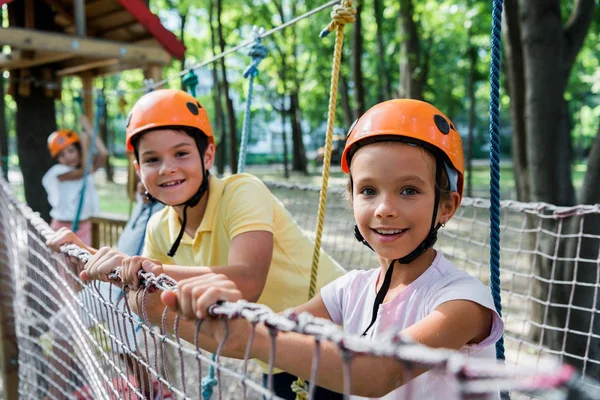 Enfoque selectivo de los niños felices en el parque de aventuras - foto de stock