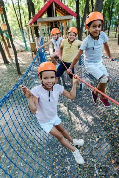 Enfoque selectivo de niños felices multiculturales en cascos - foto de stock