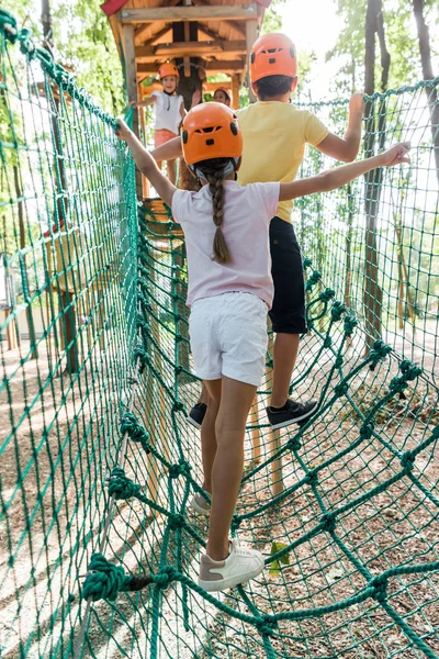 Visão traseira de crianças em pé na trilha de corda alta — Fotografia de Stock
