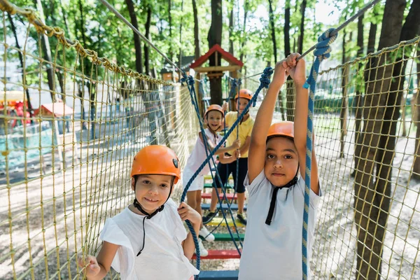 Focus selettivo dei bambini positivi e multietnici nel parco avventura — Foto stock