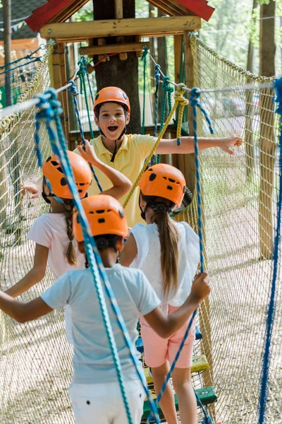 Selective focus of cheerful boy near multicultural friends in adventure park — Stock Photo