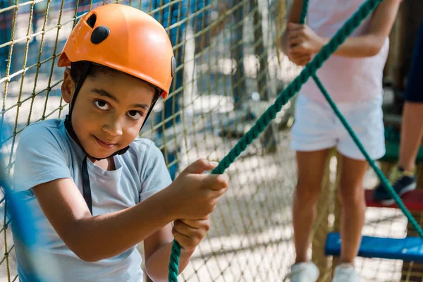 Enfoque selectivo de niño afroamericano lindo cerca de amigos - foto de stock