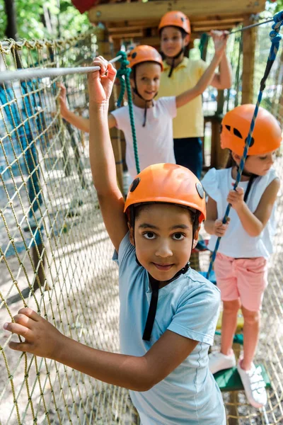 Selective focus of african american boy near happy friends in helmets — Stock Photo