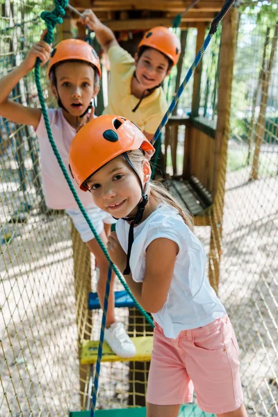 Messa a fuoco selettiva del bambino felice vicino amici carini nel parco avventura — Foto stock