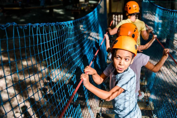 Selective focus of african american boy on high rope trail with friends — Stock Photo