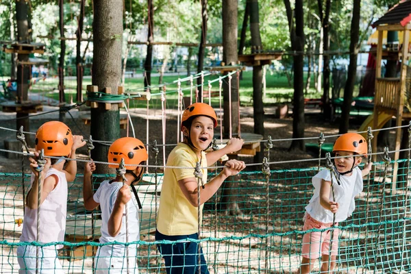 Surprised boy near cute multicultural friends in helmets — Stock Photo