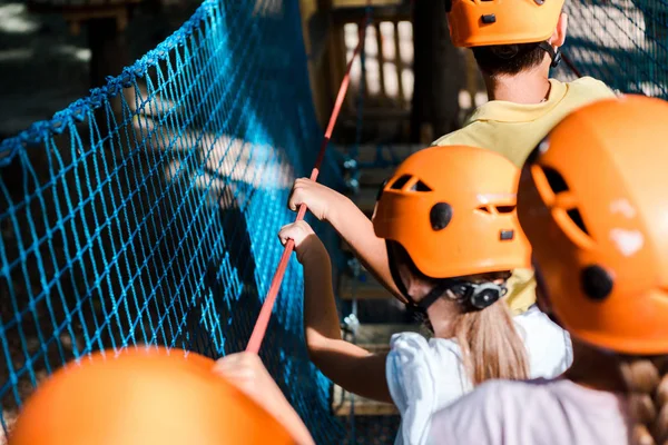 Selective focus of kids in orange helmets in adventure park — Stock Photo