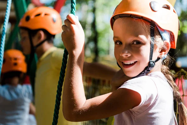 Selektiver Fokus des glücklichen Kindes im Helm in der Nähe von niedlichen Teufeln — Stockfoto