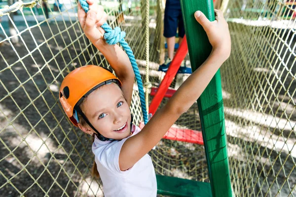 Messa a fuoco selettiva del bambino felice in casco vicino al ragazzo nel parco avventura — Foto stock