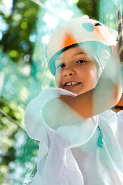 Selektiver Fokus des niedlichen Kindes mit orangefarbenem Helm, das in die Kamera blickt — Stockfoto