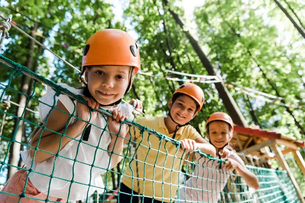 Enfoque selectivo de niño lindo cerca de amigos adorables en cascos - foto de stock