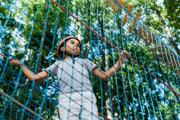 Low angle view of adorable african american boy in high rope trail — Stock Photo