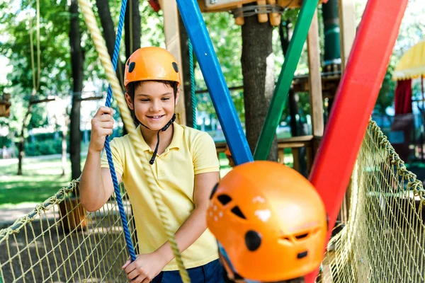 Selektiver Fokus des fröhlichen Jungen, der das Kind im Helm draußen betrachtet — Stockfoto