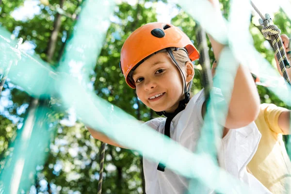 Selective focus of smiling kid in helmet outside — Stock Photo