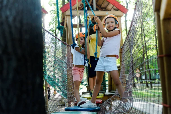 Selective focus of cute kids near boy in adventure park outside — Stock Photo