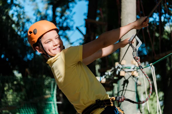 Sonriente y lindo niño en casco naranja fuera - foto de stock