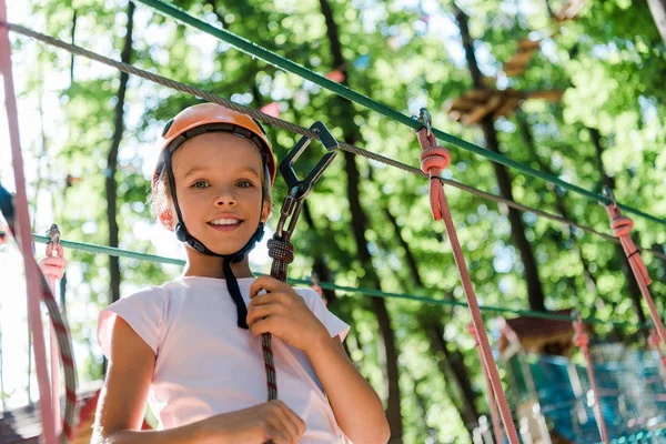 Low angle view of adorable kid in orange helmet smiling outside — Stock Photo