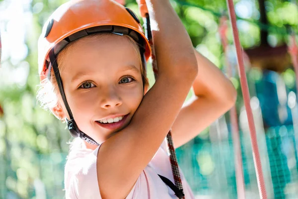 Positives Kind mit orangefarbenem Helm lächelt in die Kamera — Stockfoto
