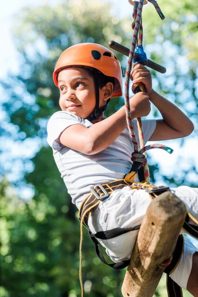 Adorabile bambino afroamericano in casco arancione nel parco avventura — Foto stock