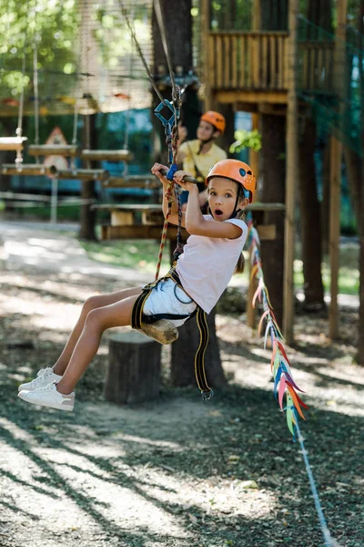 Foyer sélectif de l'enfant heureux et mignon dans l'équitation casque dans le parc d'aventure — Photo de stock