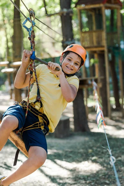 Niño feliz en casco de montar en el parque de aventuras - foto de stock