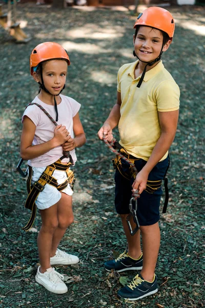 Glückliche Kinder mit Helmen, die draußen stehen und in die Kamera schauen — Stockfoto