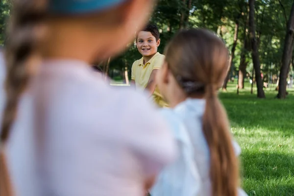 Enfoque selectivo de niños alegres compitiendo en tira y afloja fuera - foto de stock