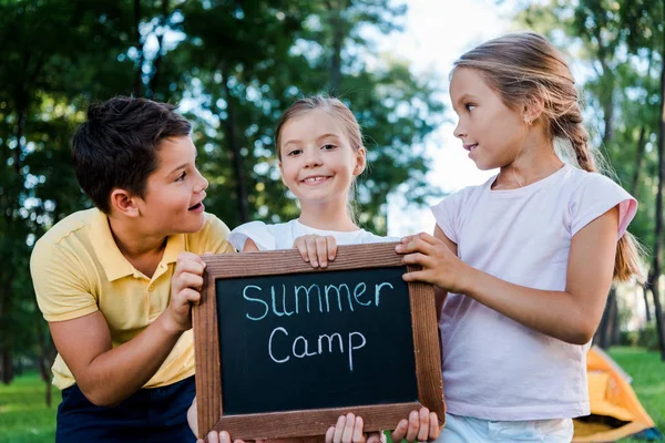 Adorable kids holding chalk board with summer camp letters — Stock Photo