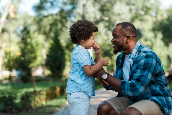 Glücklicher afrikanisch-amerikanischer Mann schaut frustrierten Lockensohn an — Stockfoto