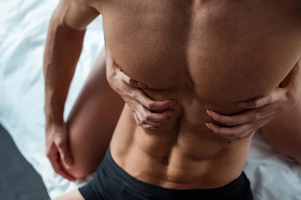 Cropped view of young woman touching shirtless sexy man — Stock Photo