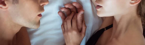 Panoramic shot of man and woman lying on bed — Stock Photo