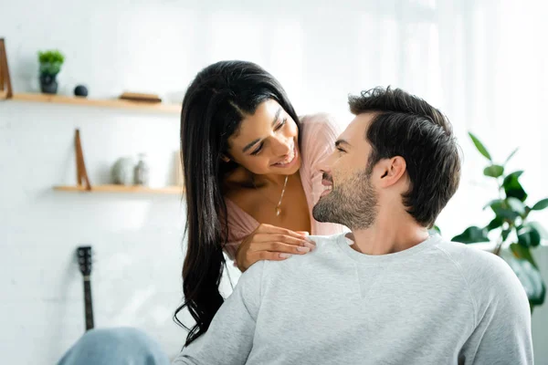 Afro-americano mulher e bonito homem sorrindo e abraçando no apartamento — Fotografia de Stock