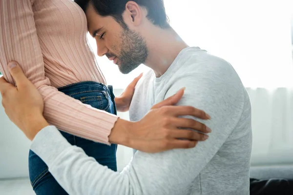 Vue recadrée de la femme afro-américaine et bel homme avec les yeux fermés étreignant dans l'appartement — Photo de stock