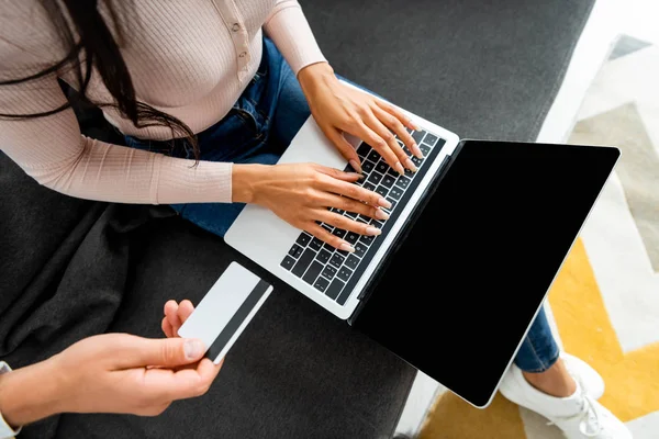 Cropped view of african american woman using laptop and man holding credit card — Stock Photo