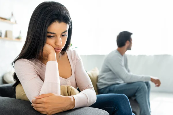 Selective focus of sad african american woman sitting on sofa — Stock Photo