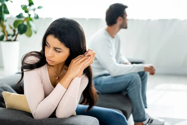 Selective focus of sad african american woman sitting on sofa — Stock Photo