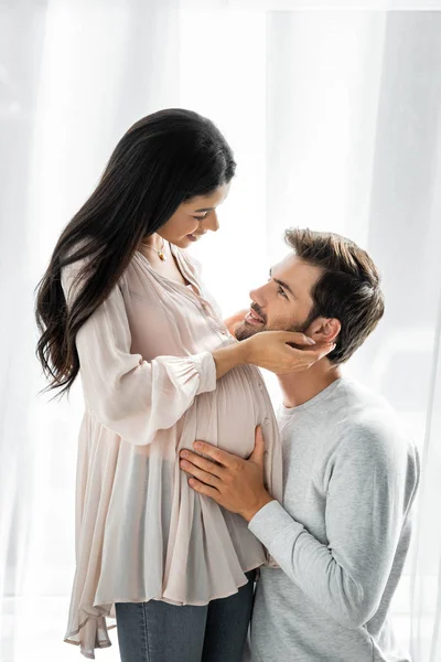 Handsome man hugging belly of his pregnant african american woman — Stock Photo