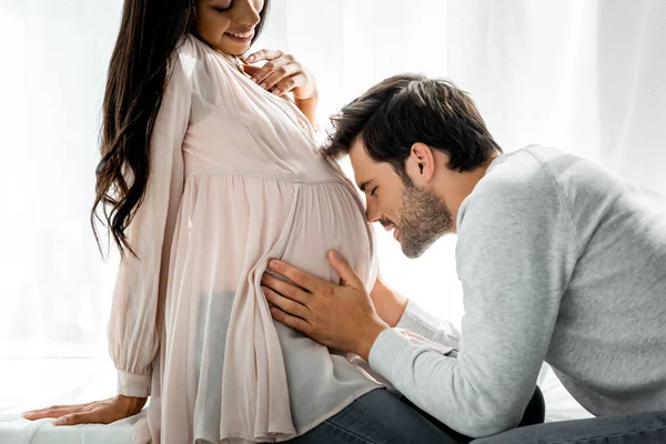 Schöner Mann umarmt Bauch seiner schwangeren Afroamerikanerin — Stockfoto