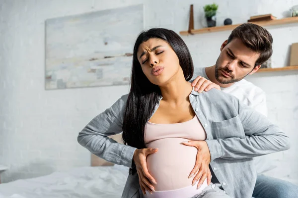 Guapo hombre haciendo masaje a embarazada africana americana mujer - foto de stock